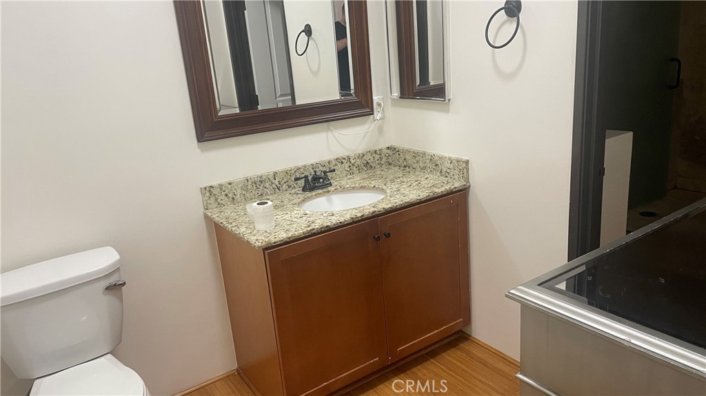 255 West 7th Street, Unit 13 San Pedro, CA 90731 - Photo 18 of 22 a bathroom with a granite countertop sink and a toilet