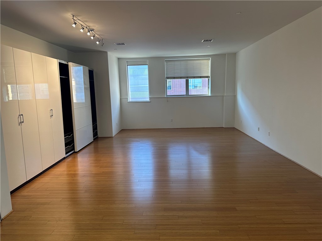 255 West 7th Street, Unit 13 San Pedro, CA 90731 - Photo 6 of 22 an empty room with wooden floor and windows