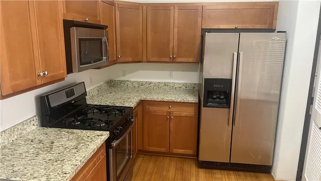 a kitchen with granite countertop cabinets and black appliances