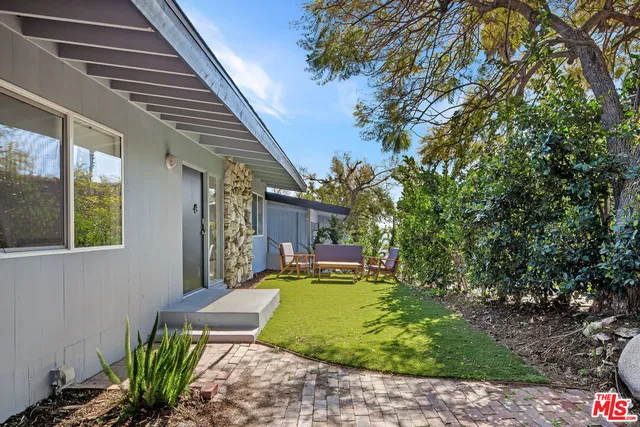 a view of a house with backyard and sitting area