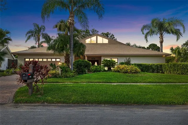 a front view of a house with a garden and trees