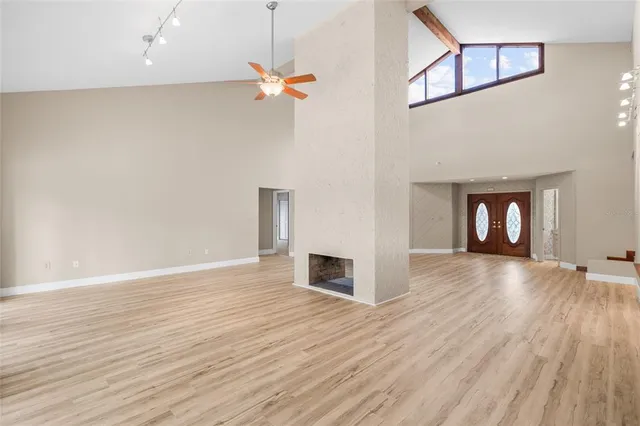 a view of a livingroom with wooden floor and a ceiling fan