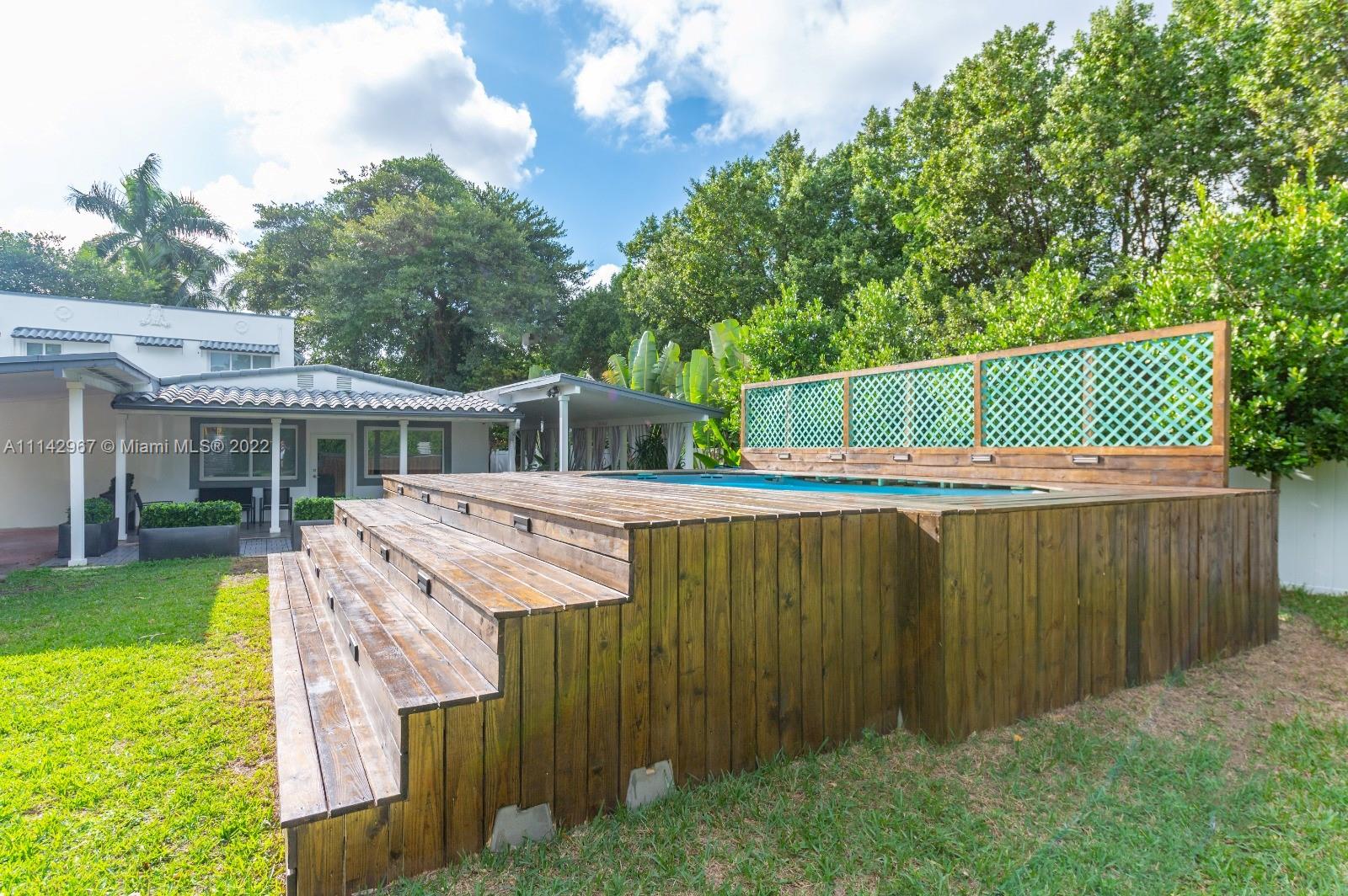 a view of a wooden deck and backyard