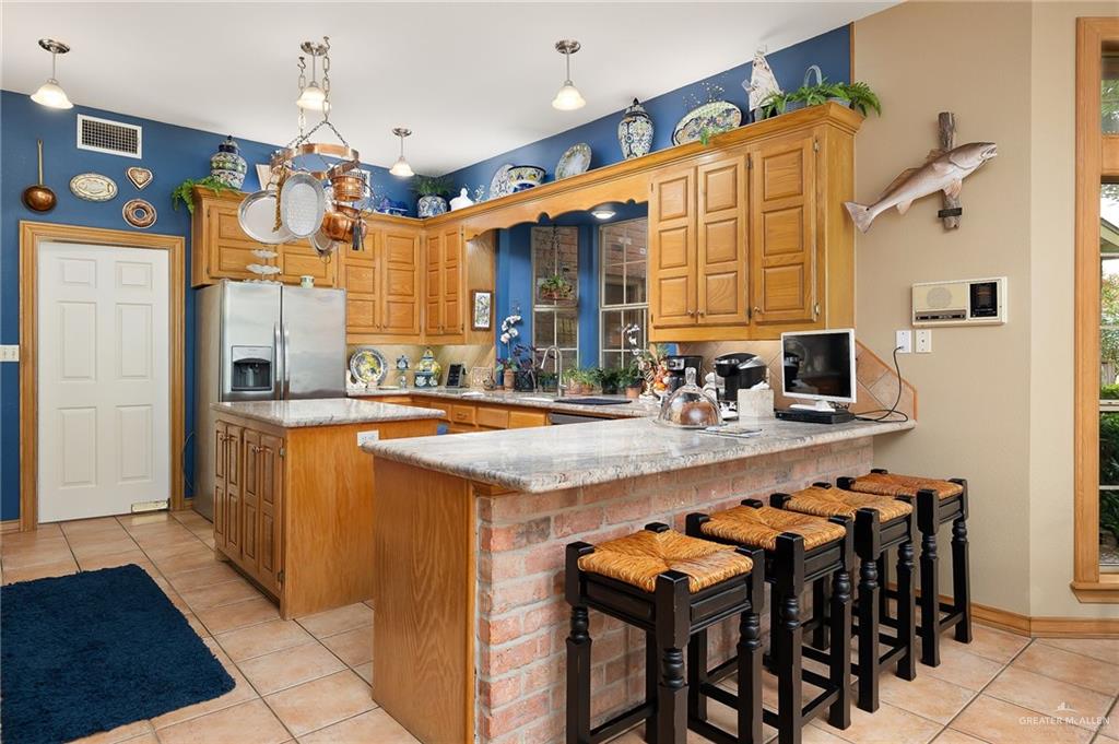 27603 Palo Verde Road San Benito, TX 78586 - Photo 16 of 45 a dining hall with stainless steel appliances granite countertop a sink and a refrigerator