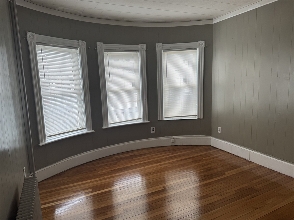 44 School Street Everett, MA 02149 - Photo 2 of 7 a view of an empty room with wooden floor and a window