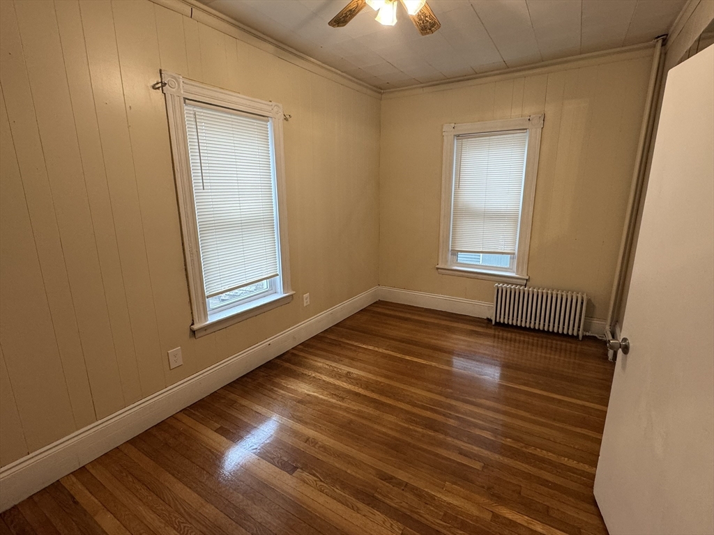 44 School Street Everett, MA 02149 - Photo 5 of 7 an empty room with wooden floor chandelier and windows