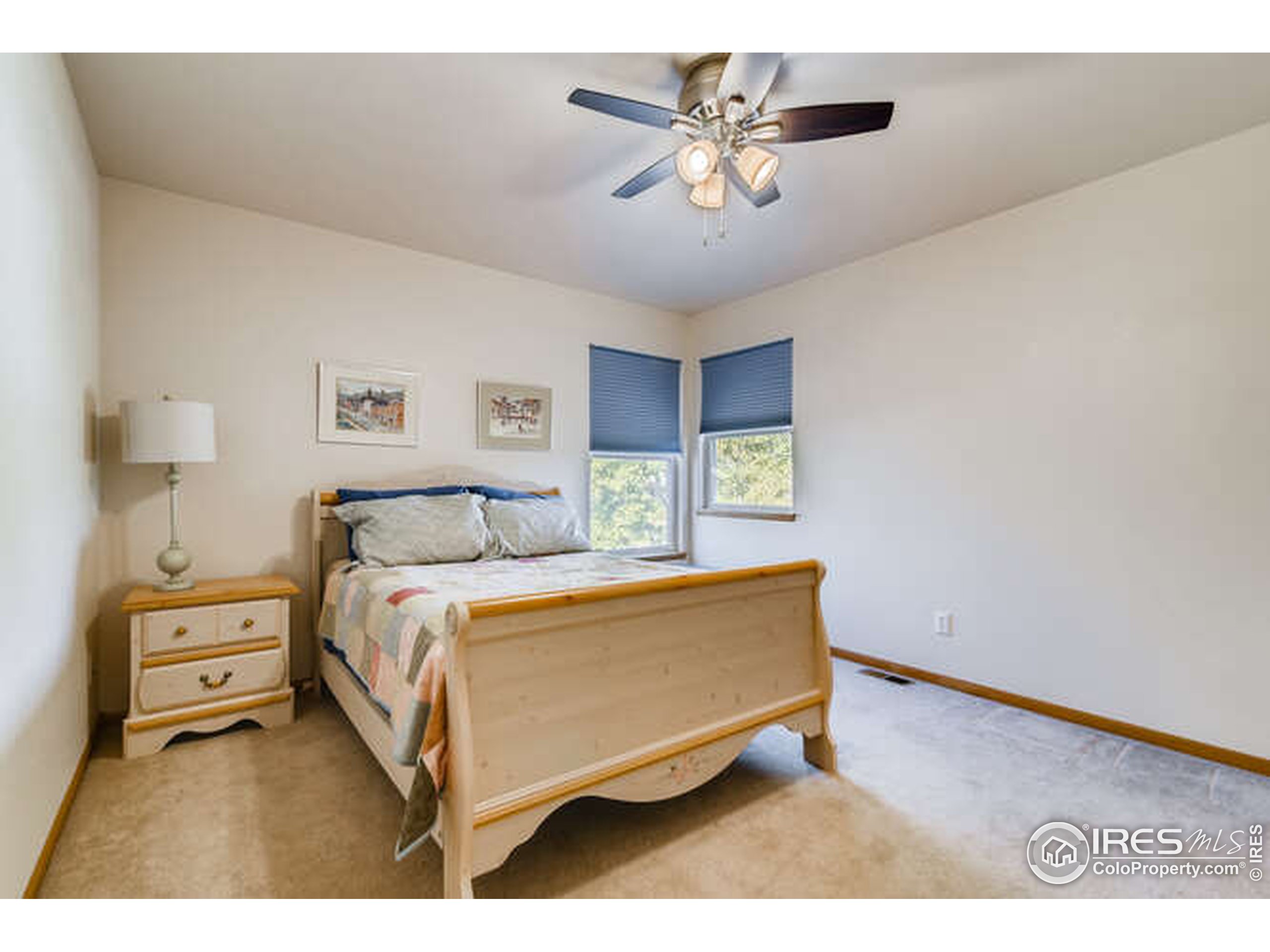 206 Victoria Street Berthoud, CO 80513 - Photo 20 of 29 a bedroom with a bed a chandelier and a table