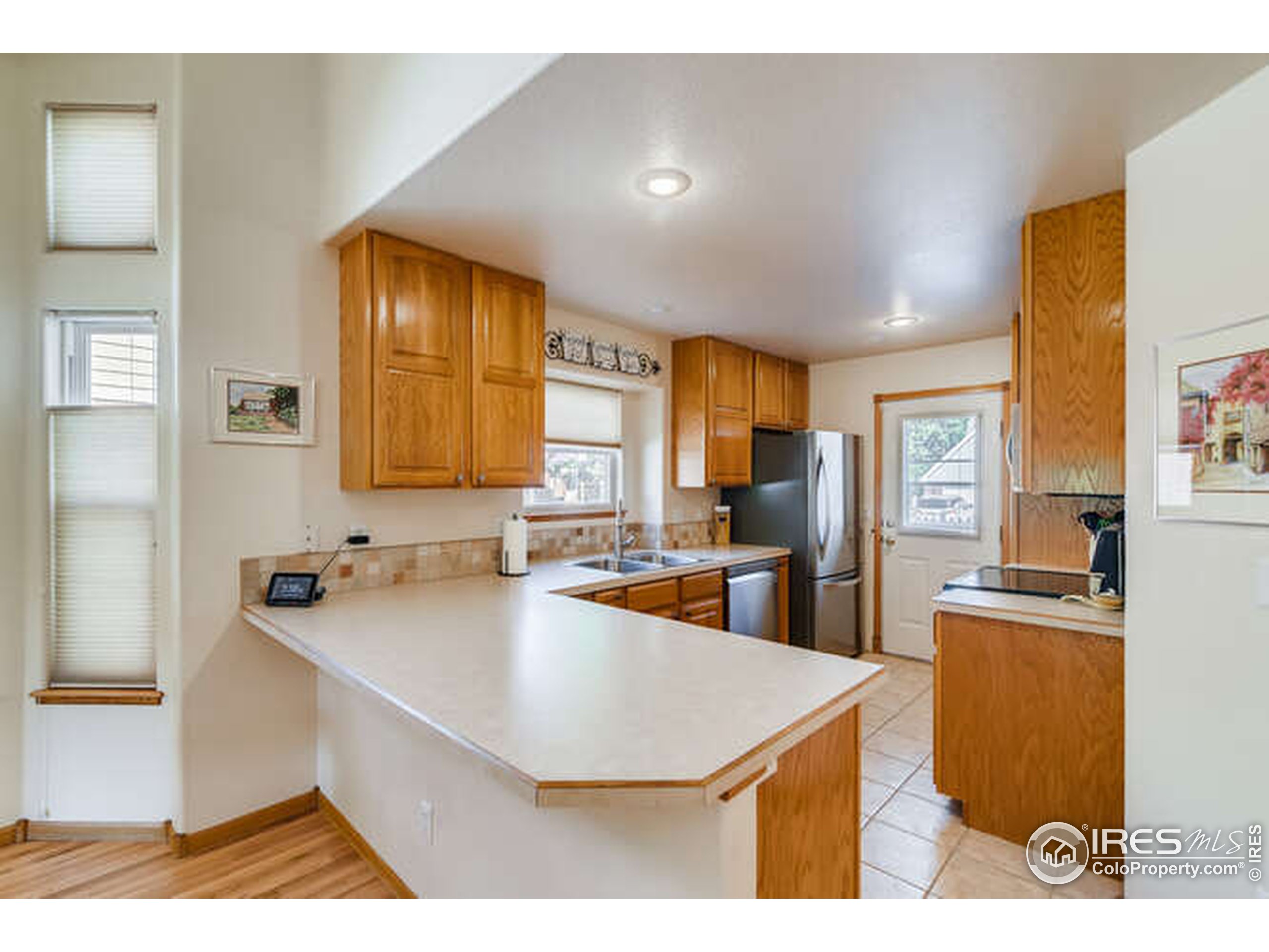 206 Victoria Street Berthoud, CO 80513 - Photo 8 of 29 a kitchen with kitchen island a sink a counter top space and living room view