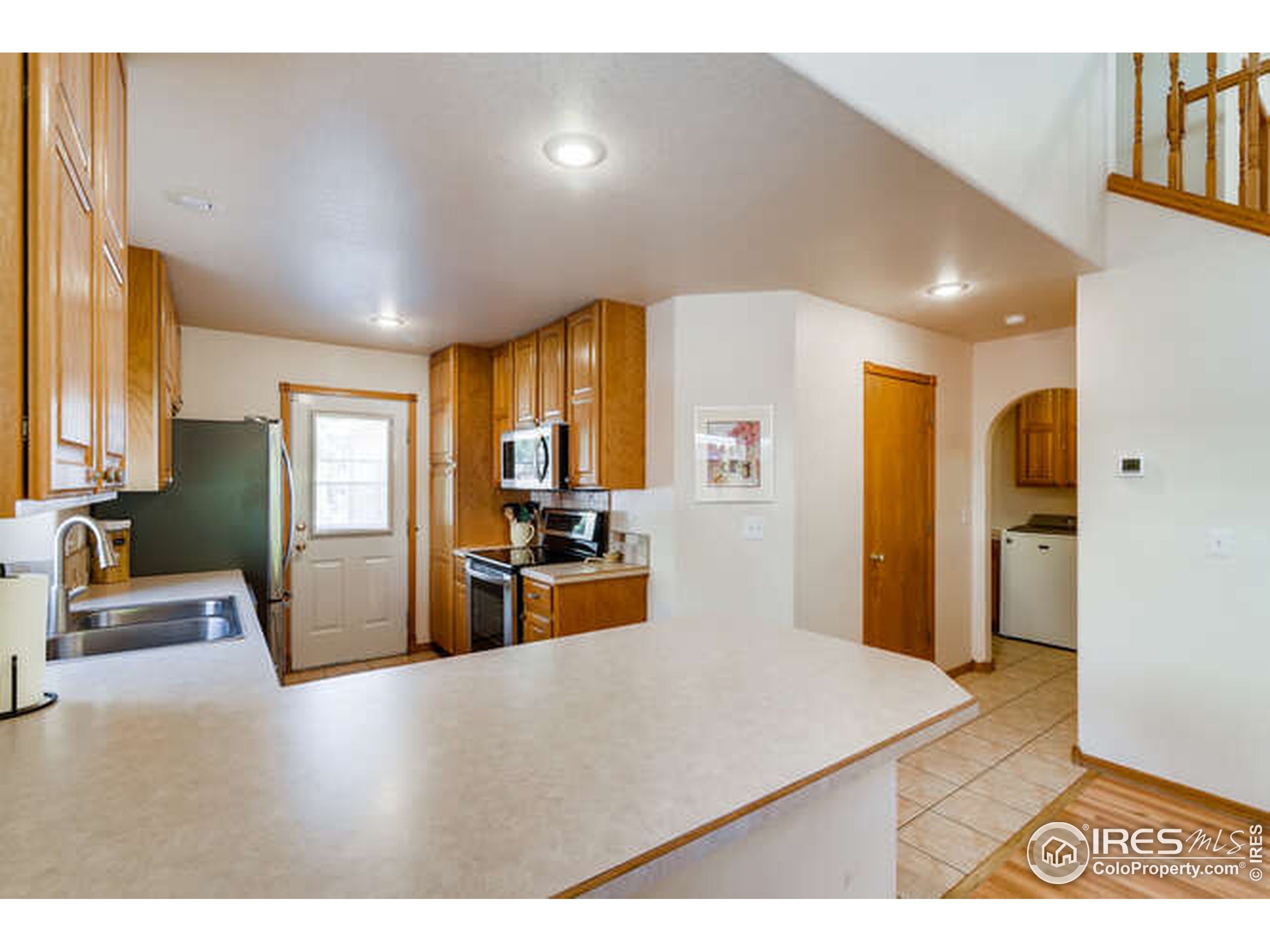 206 Victoria Street Berthoud, CO 80513 - Photo 9 of 29 a kitchen with stainless steel appliances kitchen island granite countertop a refrigerator a stove and a sink