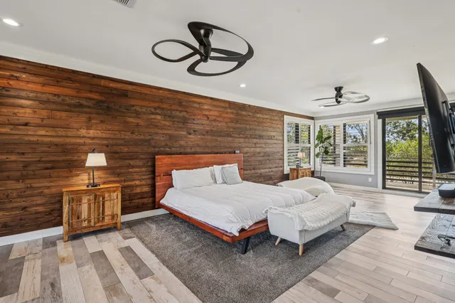 a spacious bedroom with a bed and wooden floor