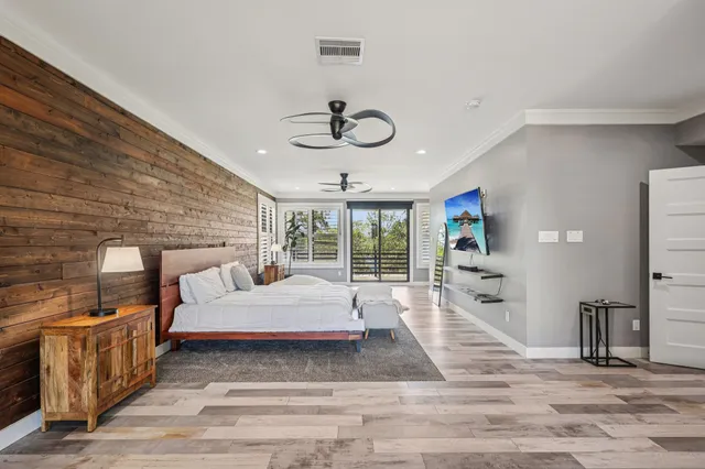 a spacious bedroom with a bed and ceiling fan