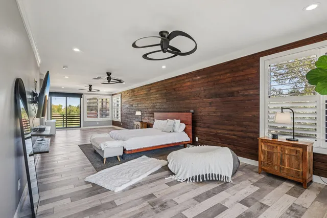 a bedroom with a bed and wooden floor