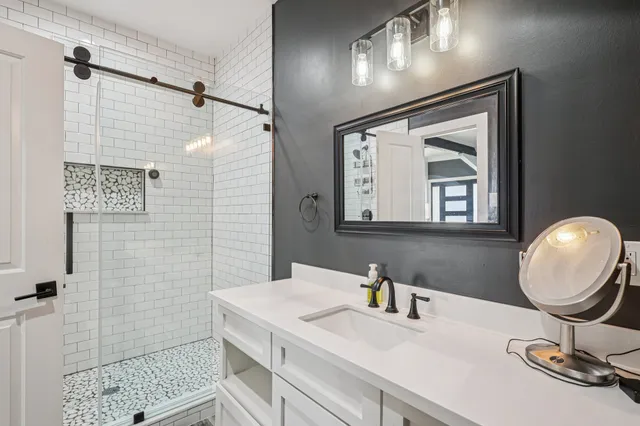a bathroom with a sink a mirror and a shower