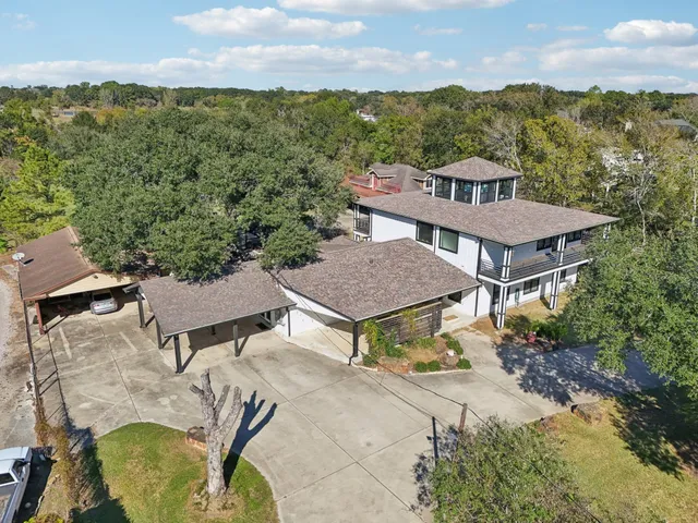 an aerial view of a house with a yard and lake view