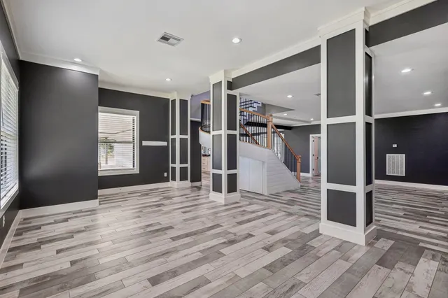 a view of a hallway with wooden floor and windows