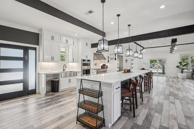 a kitchen with stainless steel appliances granite countertop a kitchen island a stove a table and chairs in it