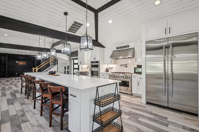 a kitchen with a table chairs stainless steel appliances and cabinets