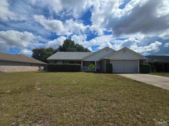 a front view of a house with a yard and a garage