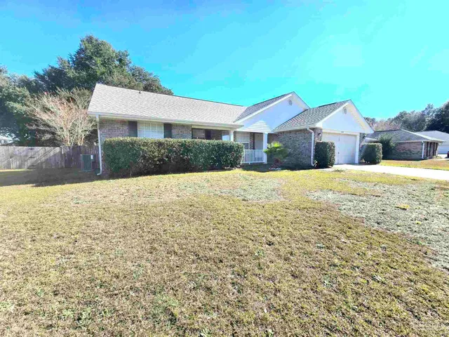 a front view of a house with a yard covered with snow