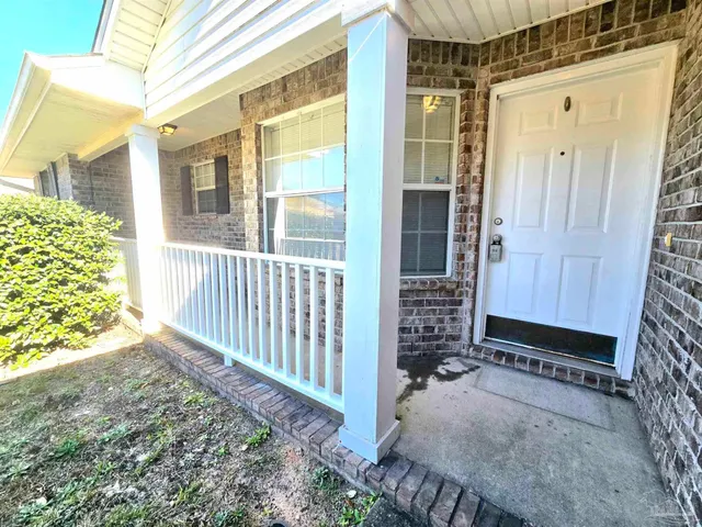 a view of a house with a small yard and wooden floor and fence