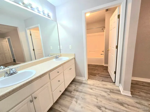 a spacious bathroom with a double vanity sink and a mirror