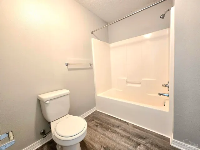 a white toilet sitting next to a bath tub