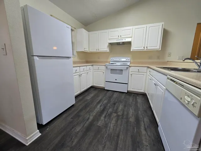 a kitchen with a sink a stove and cabinets