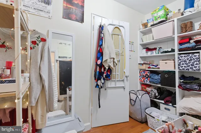 a view of walk in closet with clothes and shoes