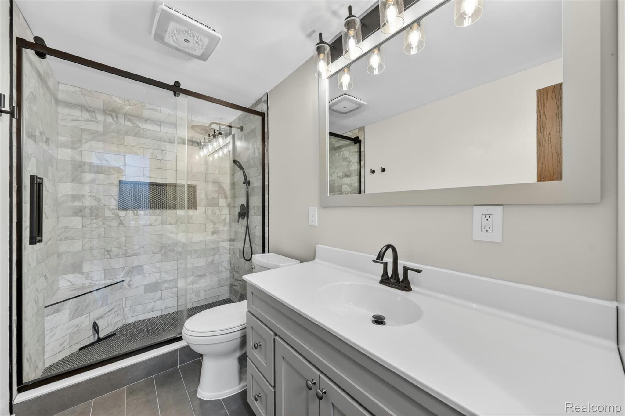 5469 Pheasant Run Road Clarkston, MI 48346 - Photo 21 of 36 Bathroom featuring a glass-enclosed shower with subway tile walls, a built-in shower niche, and a corner bench