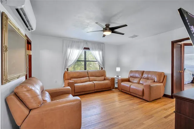 a living room with furniture and a wooden floor