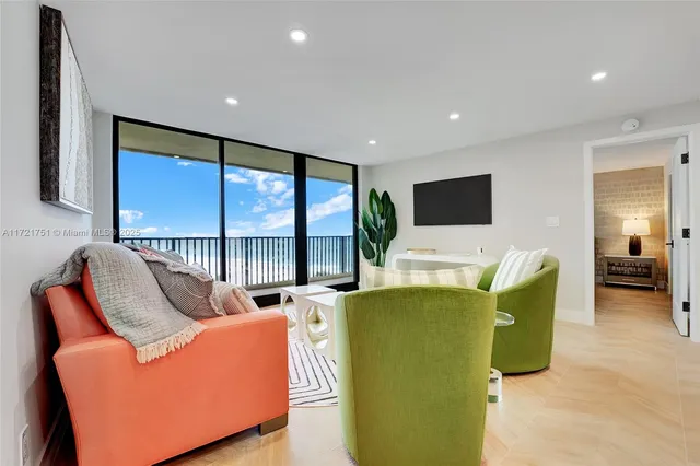 a living room with furniture a large window and a flat screen tv