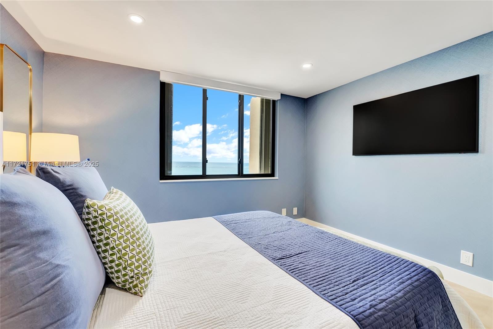 300 Ocean Trail Way, Unit 702 Jupiter, FL 33477 - Photo 16 of 30 a bedroom with a bed and a flat screen tv