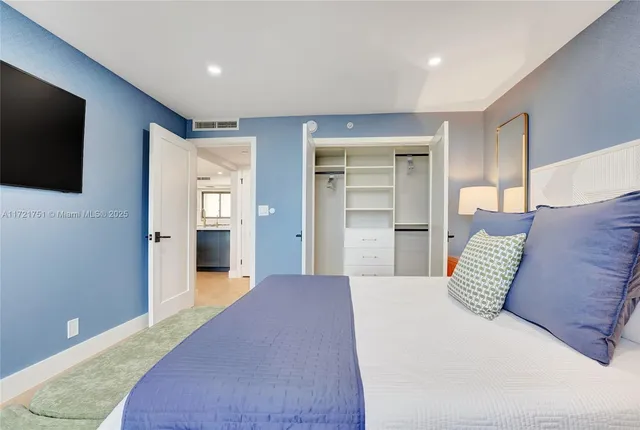 a bedroom with a large bed and a flat screen tv