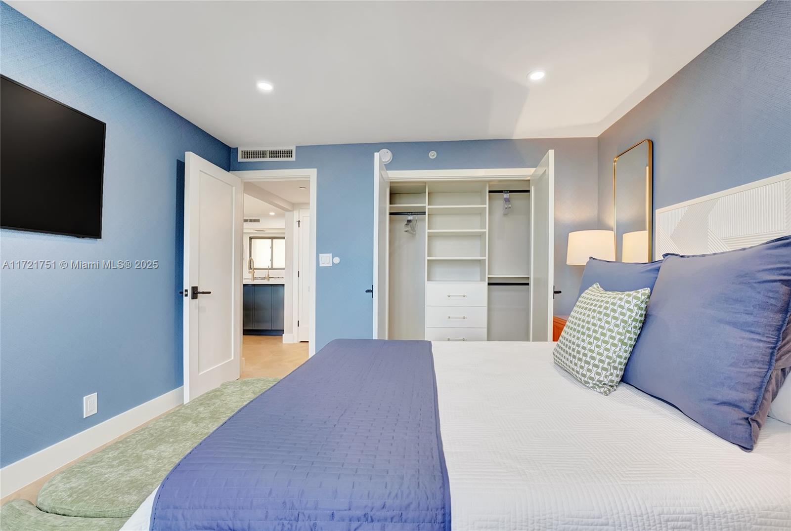 300 Ocean Trail Way, Unit 702 Jupiter, FL 33477 - Photo 18 of 30 a bedroom with a large bed and a flat screen tv