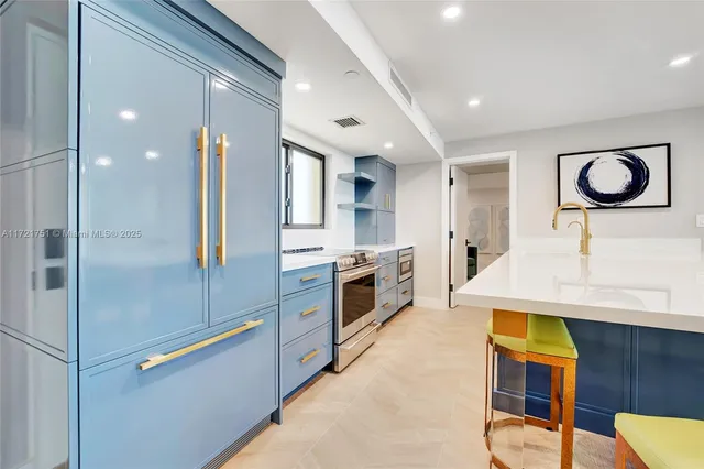 a kitchen with stainless steel appliances granite countertop a stove a sink and a refrigerator