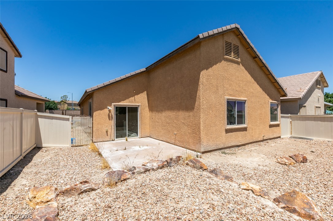 5150 Riverside Run Court North Las Vegas, NV 89081 - Photo 46 of 50 A spacious backyard with a sliding glass door provides direct access to the interior, perfect for entertaining.