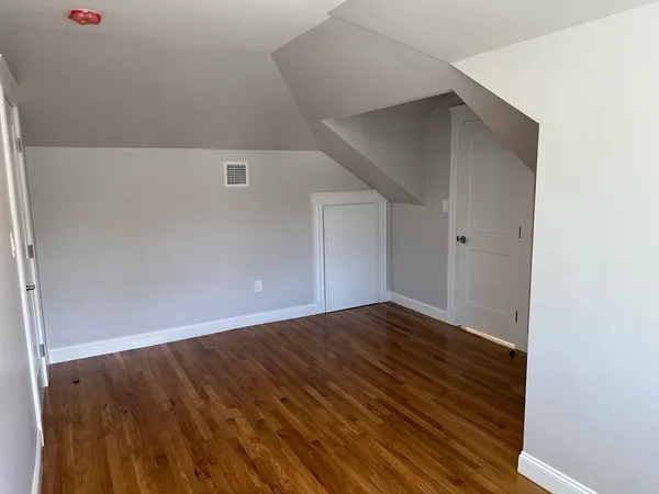 a view of an empty room with wooden floor