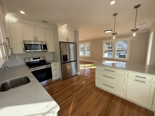 a kitchen with kitchen island white cabinets and stainless steel appliances