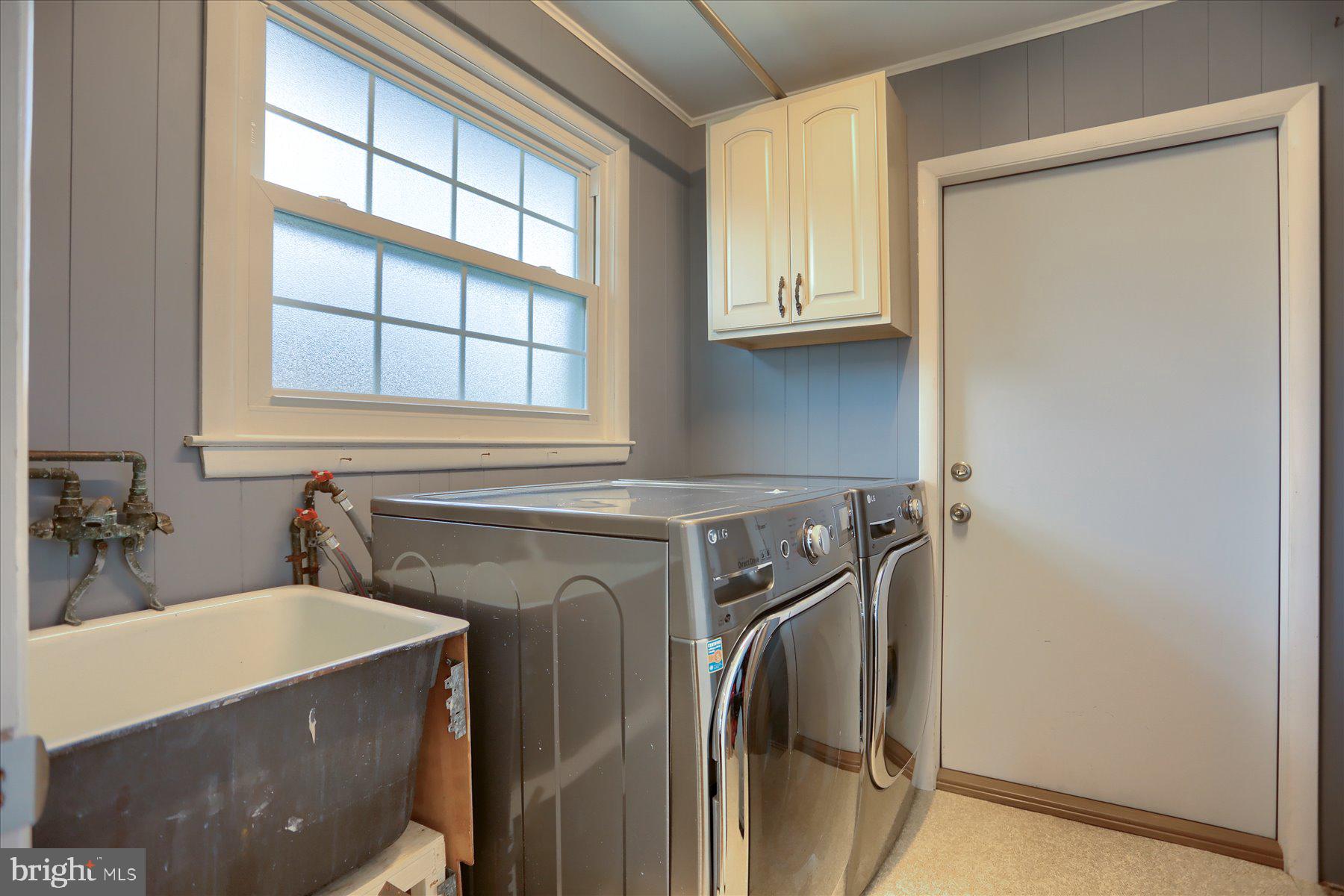 24 Neptune Drive Joppa, MD 21085 - Photo 39 of 70 a bathroom with a sink a washer and dryer next to a window