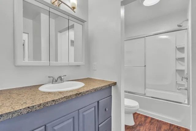 a bathroom with a granite countertop sink toilet and shower