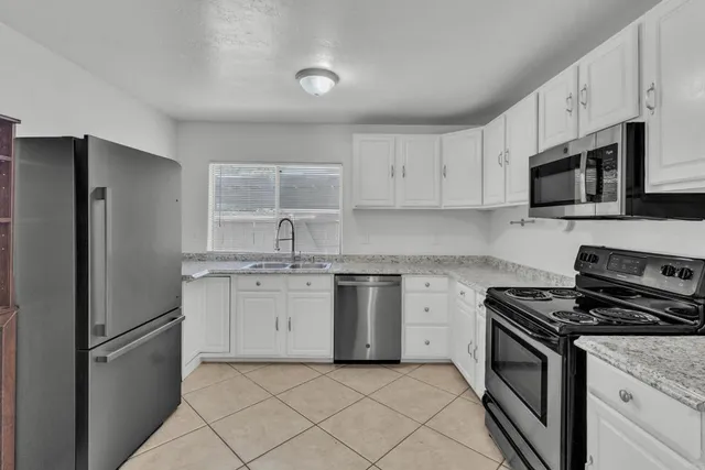 a kitchen with appliances a sink and cabinets