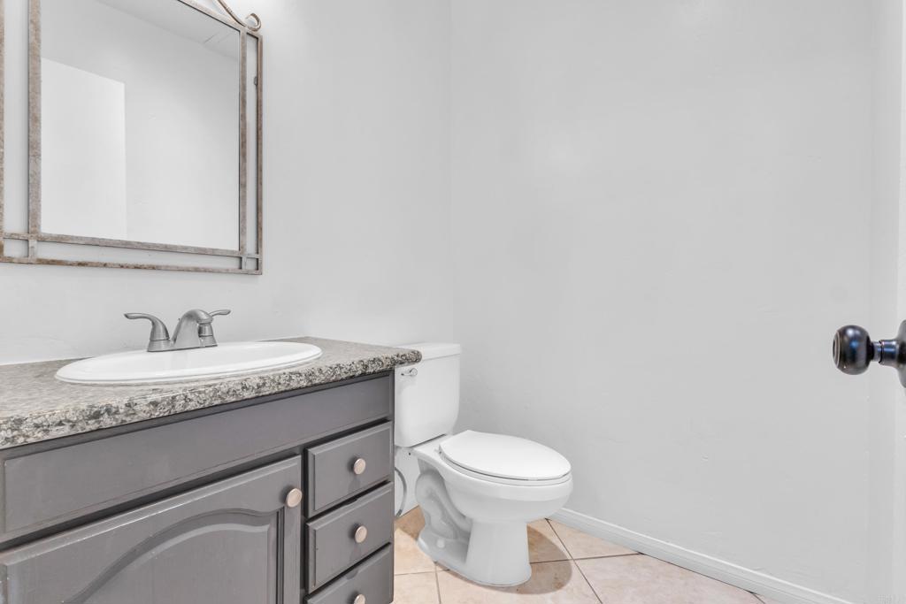 237 Rancho Drive, Unit C Chula Vista, CA 91911 - Photo 6 of 23 a bathroom with a granite countertop sink a toilet and a mirror