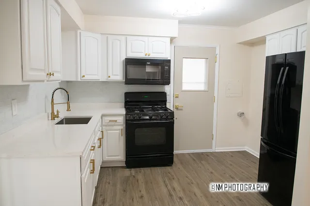 a kitchen with a refrigerator stove and white cabinets
