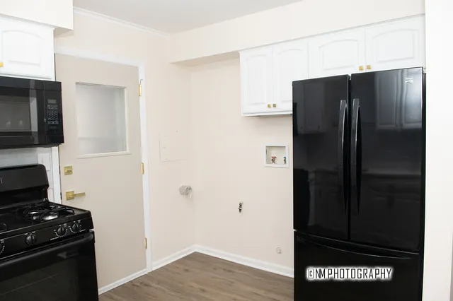a kitchen with a refrigerator and a stove top oven