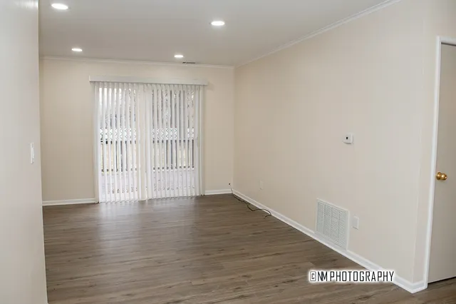 a view of an empty room with wooden floor
