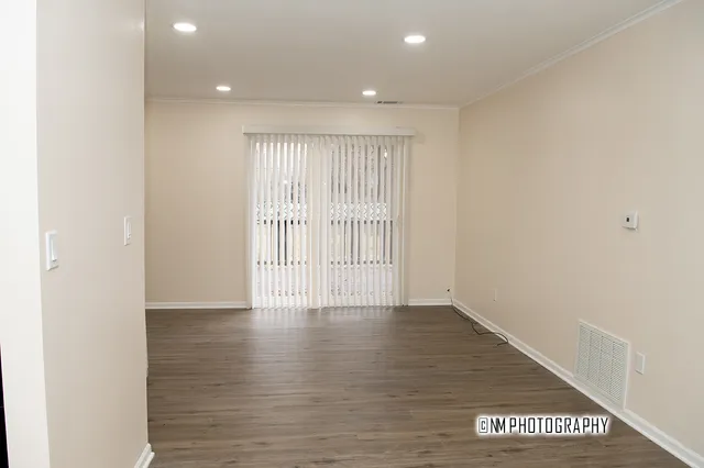 a view of an empty room with wooden floor