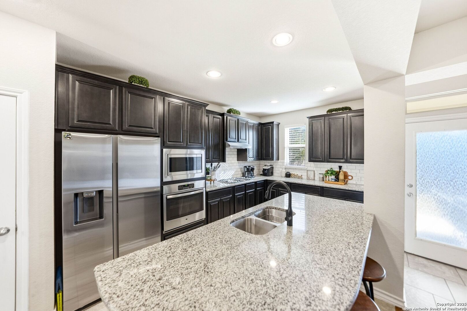 30622 Horseshoe Path Bulverde, TX 78163 - Photo 7 of 44 a kitchen with granite countertop a refrigerator and a stove top oven