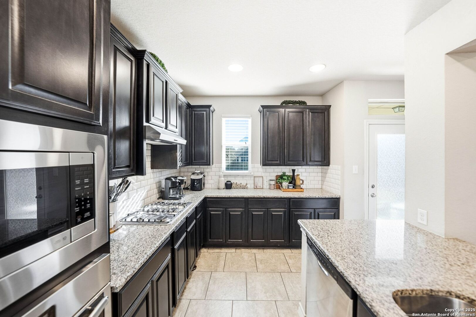 30622 Horseshoe Path Bulverde, TX 78163 - Photo 8 of 44 a large kitchen with kitchen island granite countertop a sink and cabinets