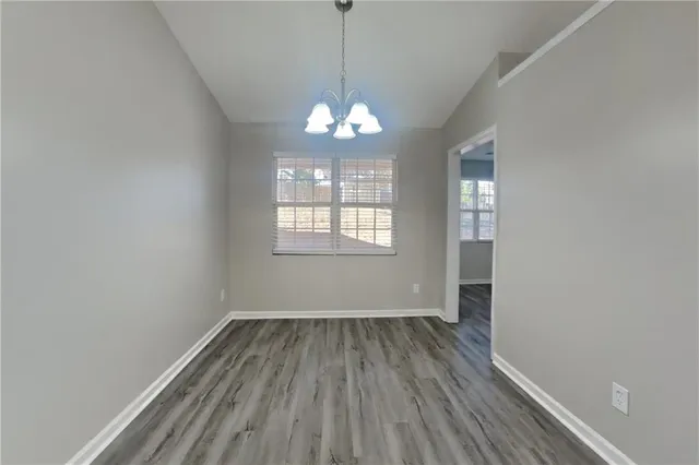 a room with wooden floor chandelier and window