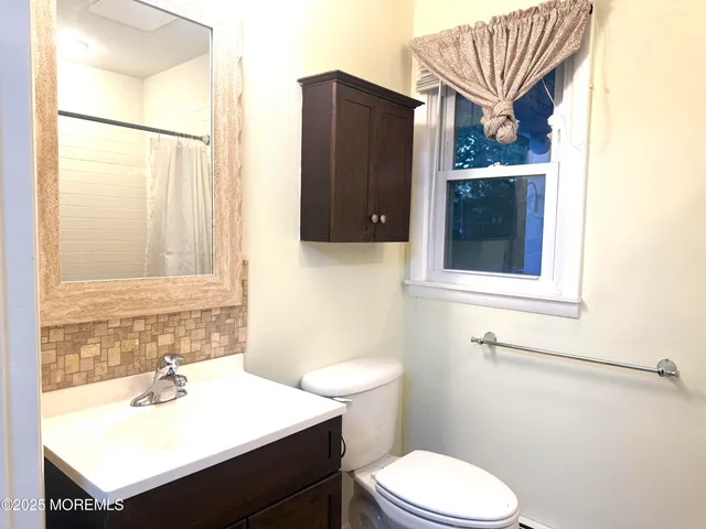 a bathroom with a sink toilet and mirror